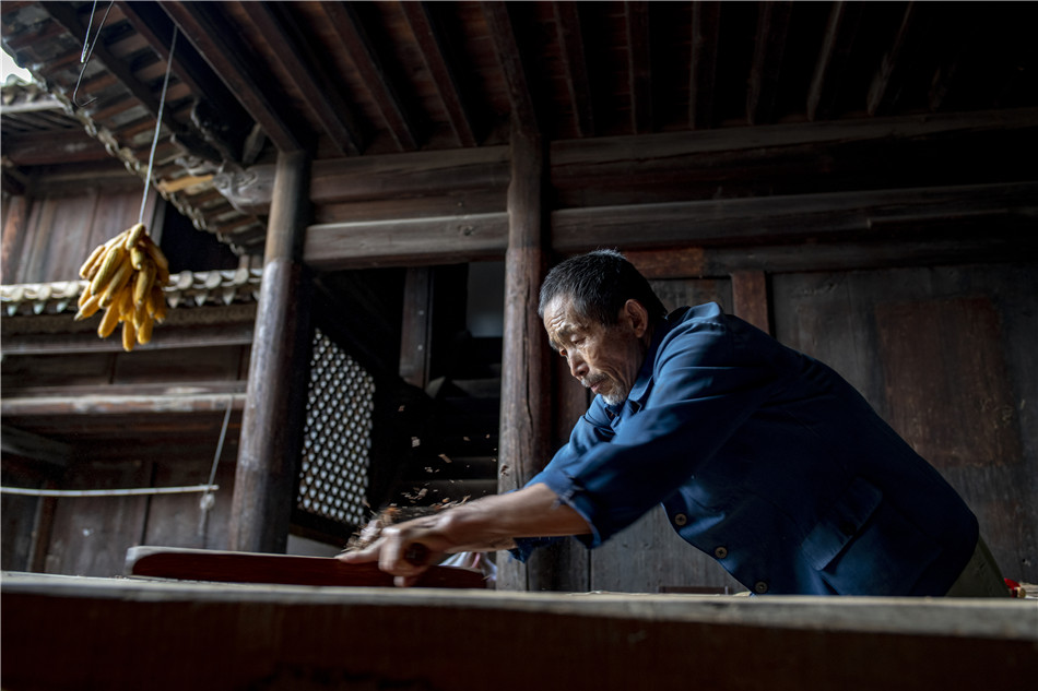 Yang makes wood beams by hand